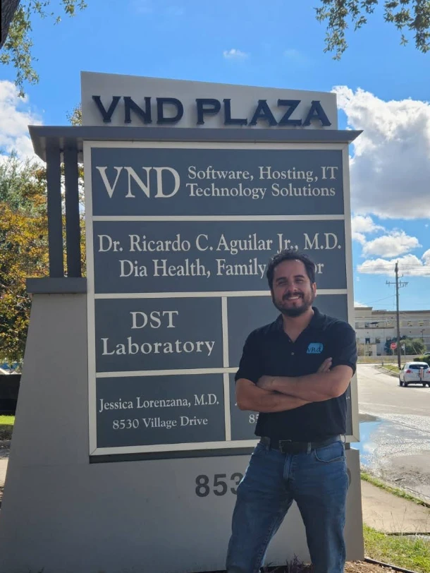 Javier Oblitas next to the VND Plaza sign, 2022